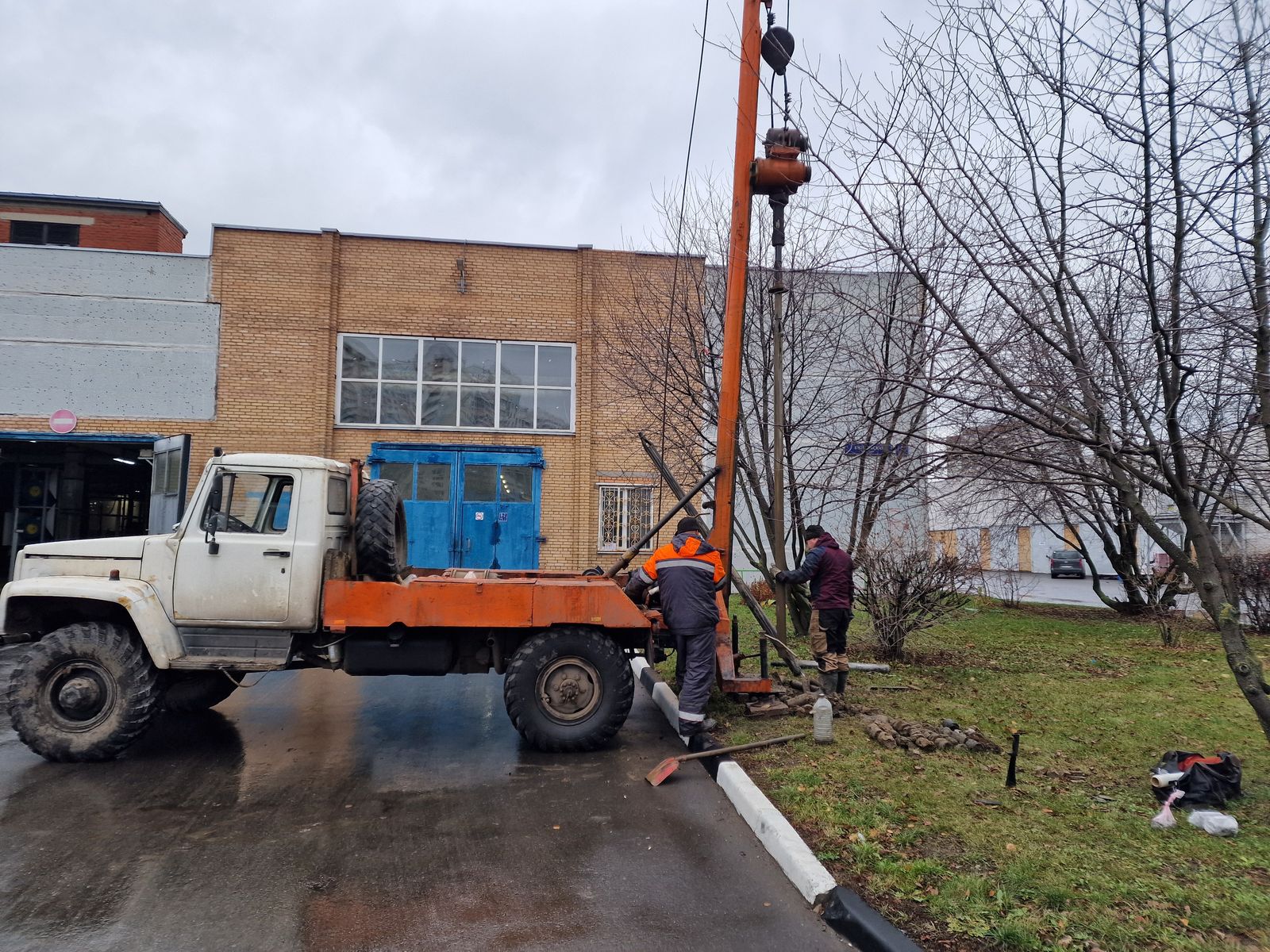 Бурение геологической скважины у кирпичного торца здания